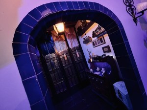 A tile archway in a market, beyond is a display and large curtains with tassels.