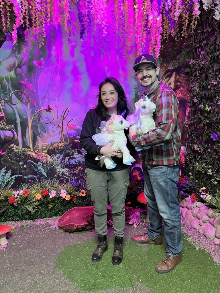 David and Peih-Gee standing together cuddling baby unicorns.