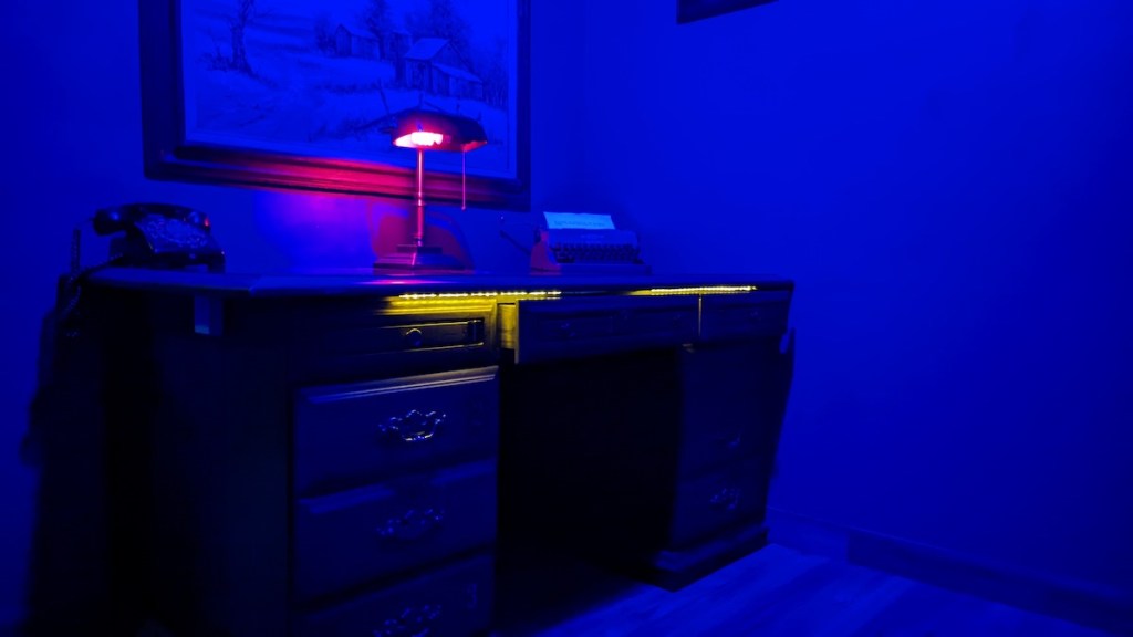 A desk in a dim, blue-lit office.