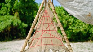 triangle puzzle printed on canvas lashed to a bamboo frame on a beach