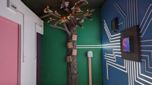 A tree made of books connected by strands of lights to a representation of a brain.