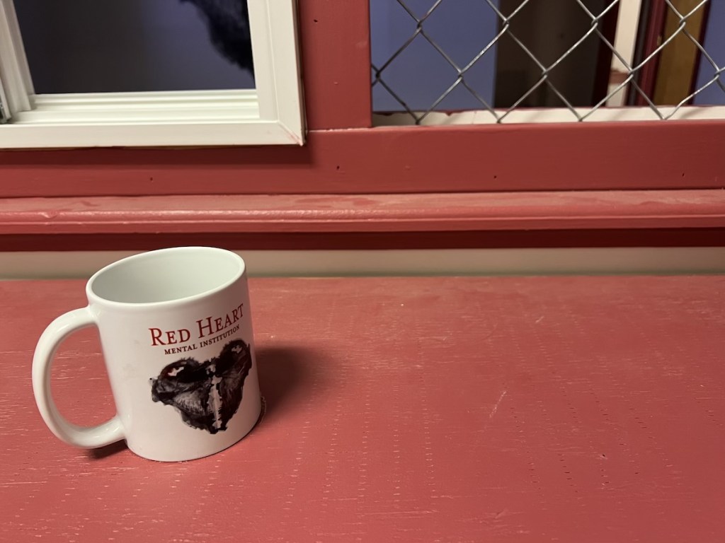 A white much with the words "Red Heart Mental Institution" on a red table.