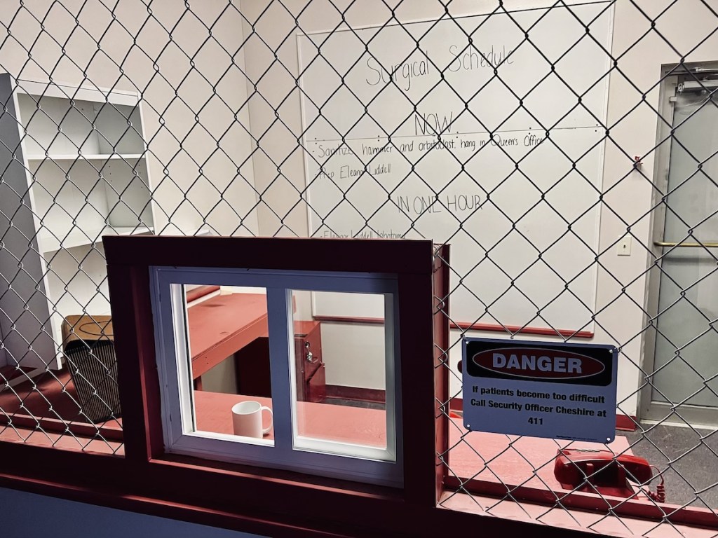A caged in desk in a hospital. It looks both bare and imposing.