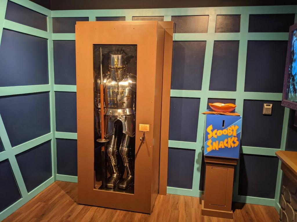 A case with knight's armor beside a box of Scooby Snacks.