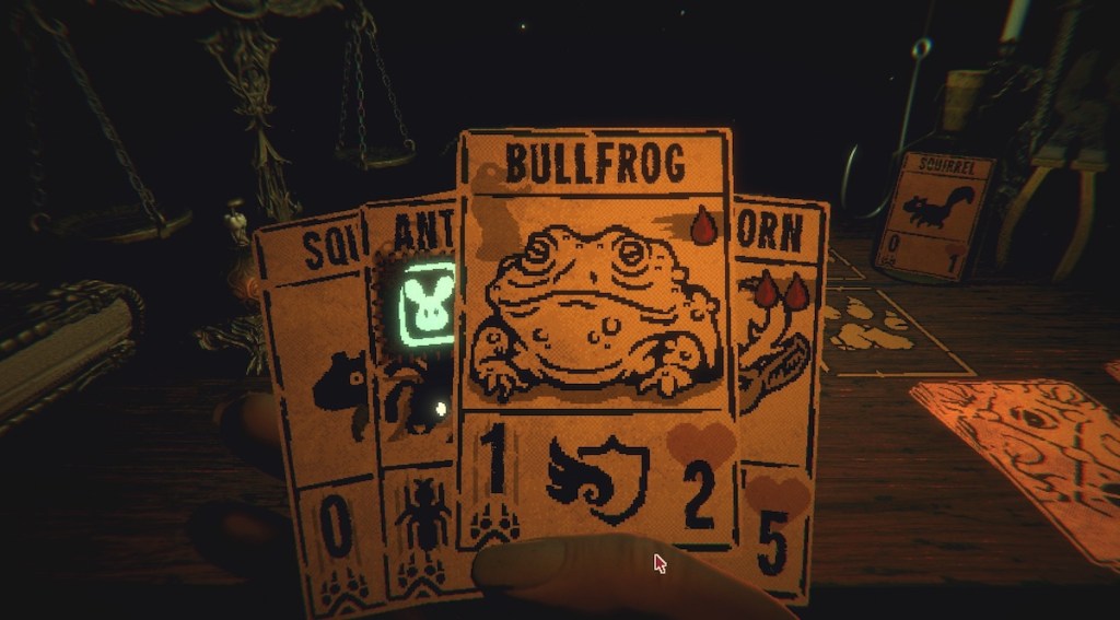 Closeup of a player's hand of cards, a bullfrog is the top card.