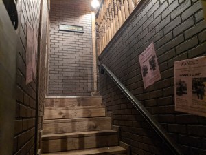 A wood stairwell flanked by brick.