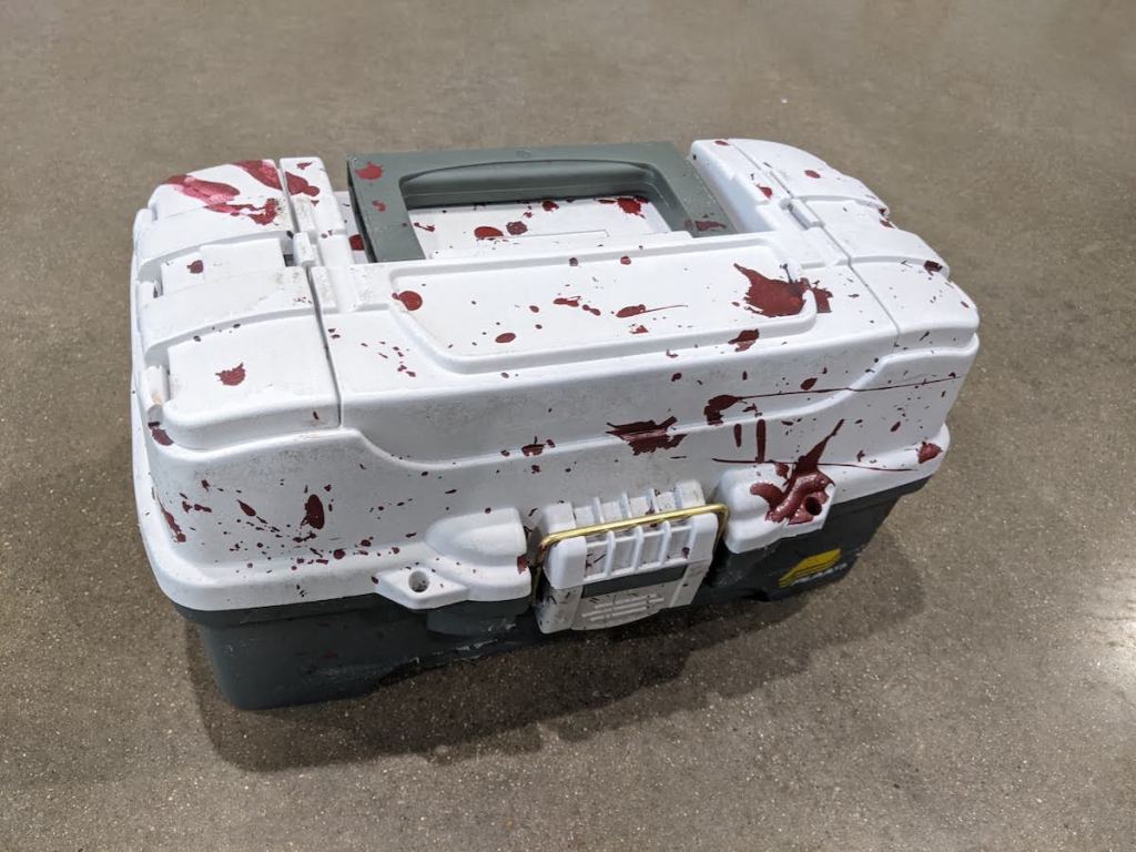 Closeup of a bloodied tacklebox.
