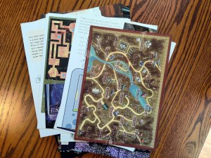 An intricate map puzzle laying on top of a stack of pages.