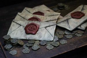 An assortment of envelopes sealed with wax, atop pirate treasure.