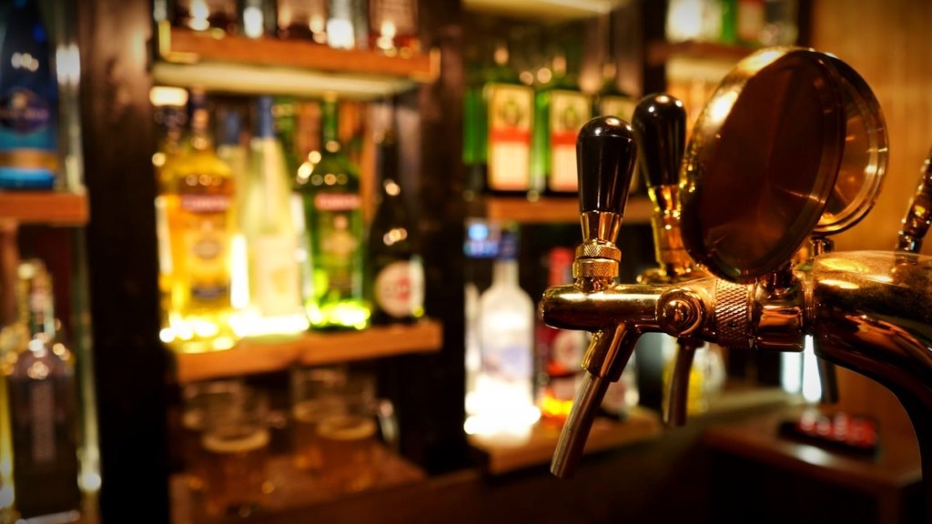 Closeup of a beer tap in a dramatically lit bar.