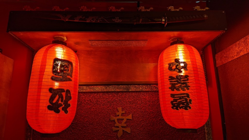 A pair of red paper lanterns hung beneath a katana.