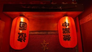 A pair of red paper lanterns hung beneath a katana.