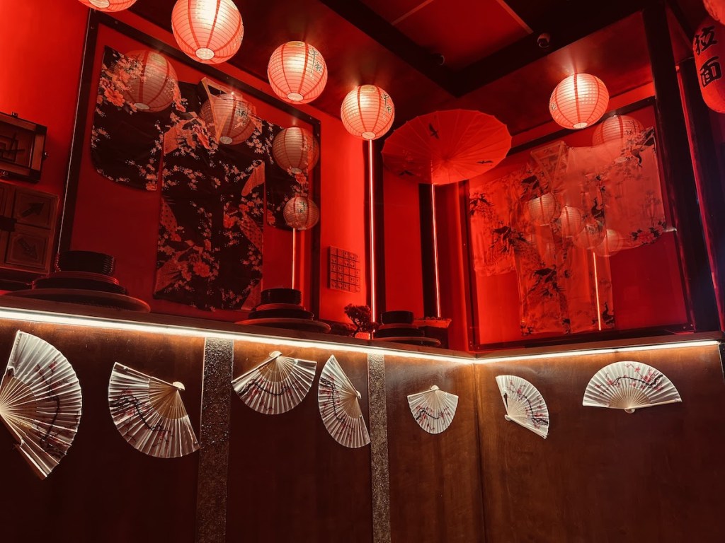 A series of red paper lanterns and white fans hung on the wall.