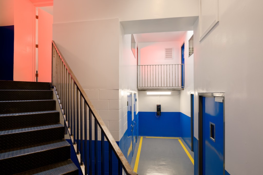 A hallway and a stairwell in a prison.