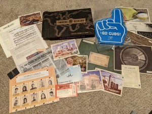 Finders Seekers box beside an assortment of paper components and a large, blue, foam hand that reads, "Go Cubs!"