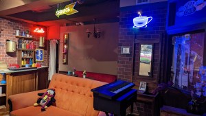 An orange couch beside a keyboard, and many assorted items.