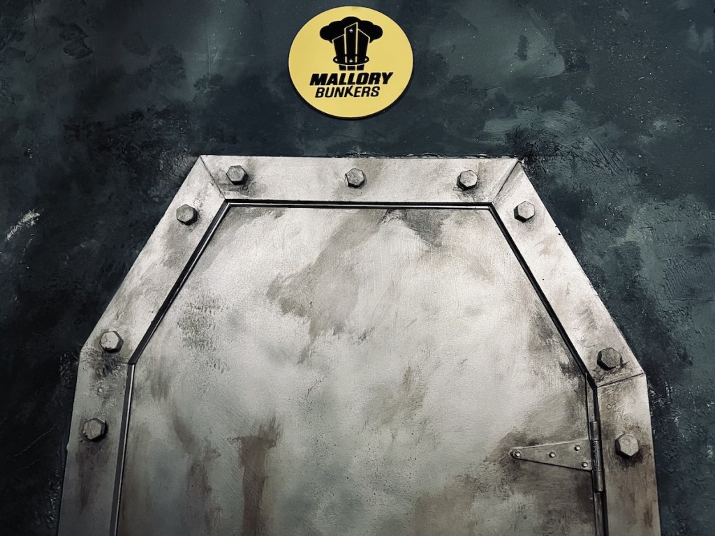 A big, metal door with a yellow sign that reads, "Mallory Bunkers"