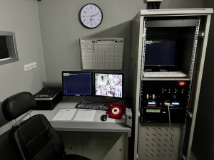 A computer, a red phone, and a server rack.