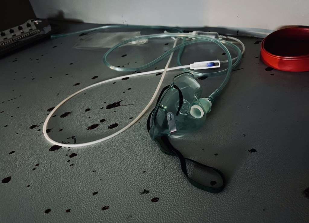 Closeup of medical equipment with blood spatter on the surface below.