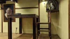 A small desk with strange art around it.