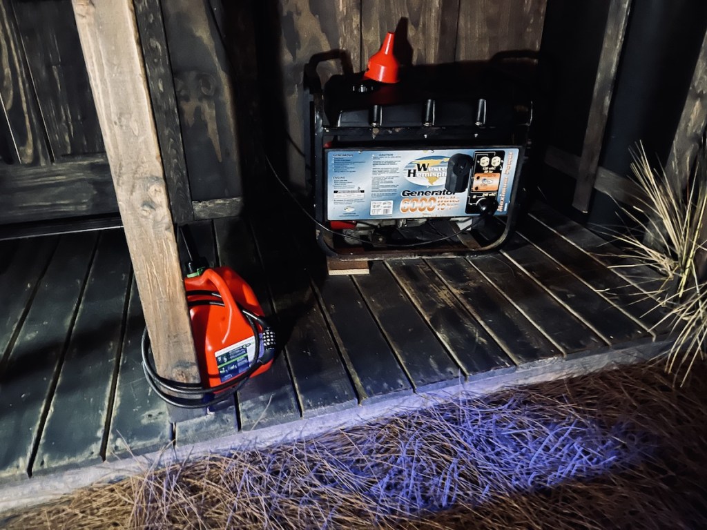 A backup generator beside a fuel can that is bike locked to a post.