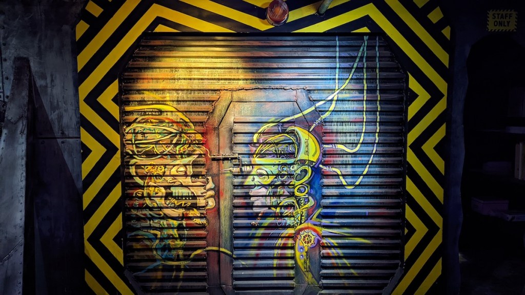 Heavy garage door with paintings of robots on it.