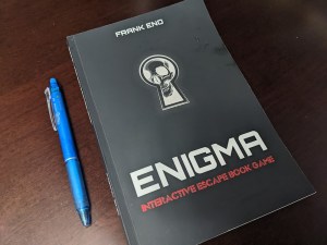 Enigma: Interactive Escape Book Game by Frank Eno. The cover is black with a keyhole, peering through it is a human skull.