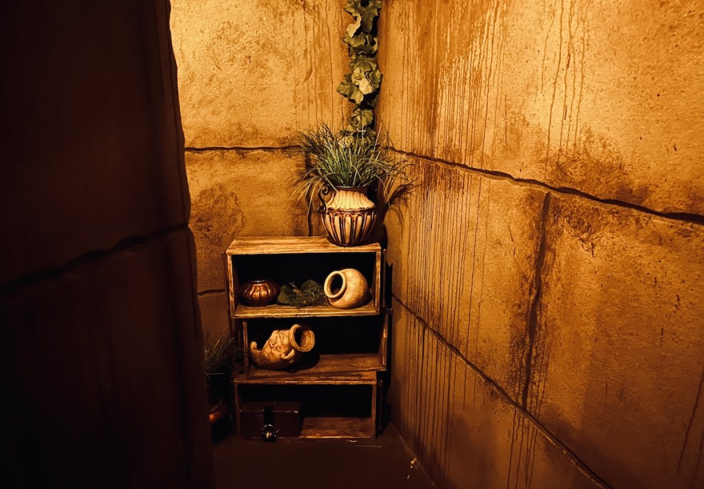 Old temple walls and a stack of crates with vases.