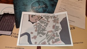 Detective Society box with assorted pieces of evidence, and a map of Folklore Falls.