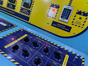 Blue and yellow submarine control panels includes dial switches, keypad, indicator lights, and gauges.