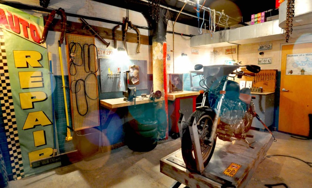 A body shop interior with a motorcycle being worked on.