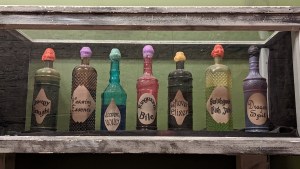 A display with 7 bottled magical components each with a different look and label.