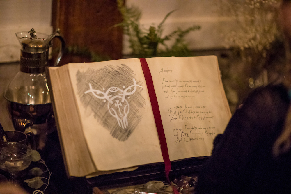 A codex open to a page with writing and a sigil.