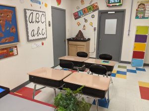 An assortment of desks and chairs in a colorful 4th grade classroom.
