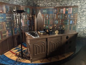 A wizard's study with a large desk surrounded by books