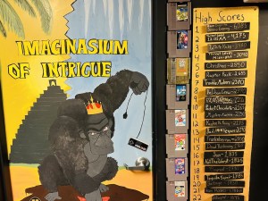 Imaginasium of Intrigue's door with a royal ape holding a Nintendo controller, the door is framed with Nintendo cartridges, and along the side are a series high scores.