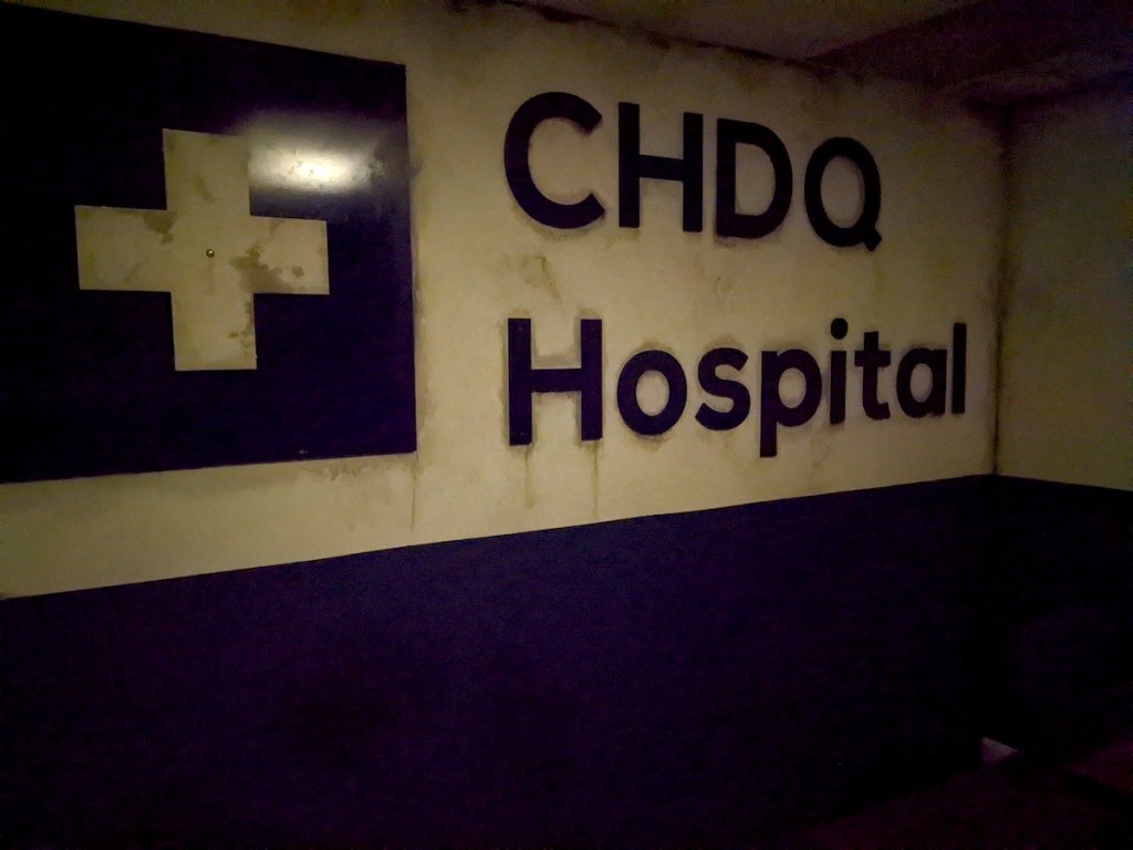 An old, worn sign for CHDQ Hospital. It looks dingy.