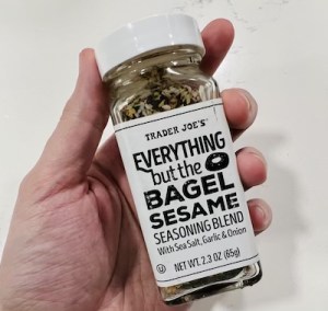 Hand holding Trader Joe's Everything but the Bagel Seasoning Blend.