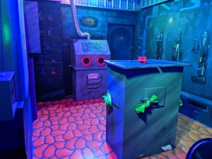A secret lair-environment with sci-fi blasters on the walls and experiment stations.