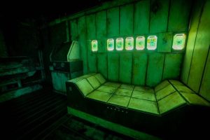 A strange, futuristic, curved bed in a dirty, green-lit science lab.