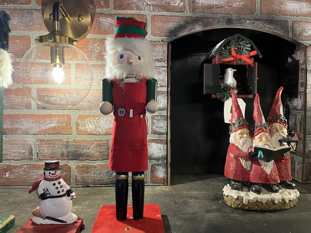 A nutcracker beside some other Christmas tchotchkes.