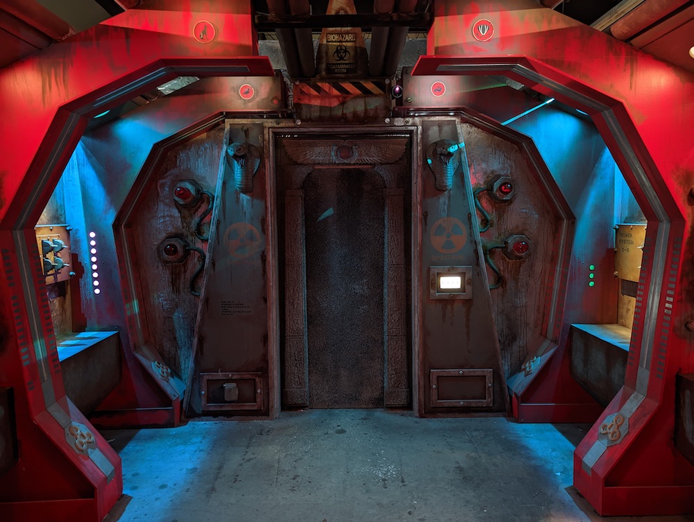 A futuristic red metal bunker adorned with strange ancient Egyptian statues and art.