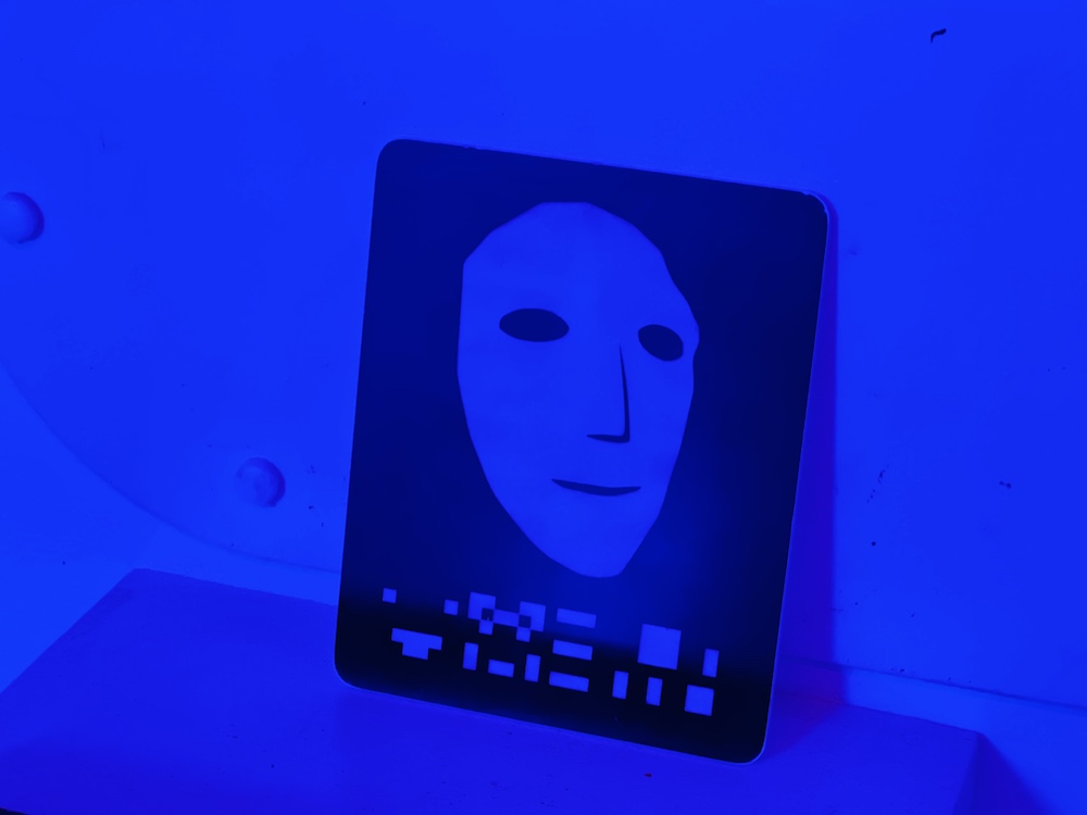 Closeup of a white, computer rendered face. A series of strange symbols are under it.