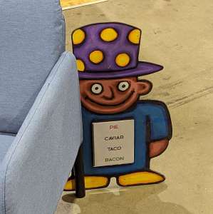 Alien cardboard standee whose shirt reads, "PIE CAVIAR TACO BACON"