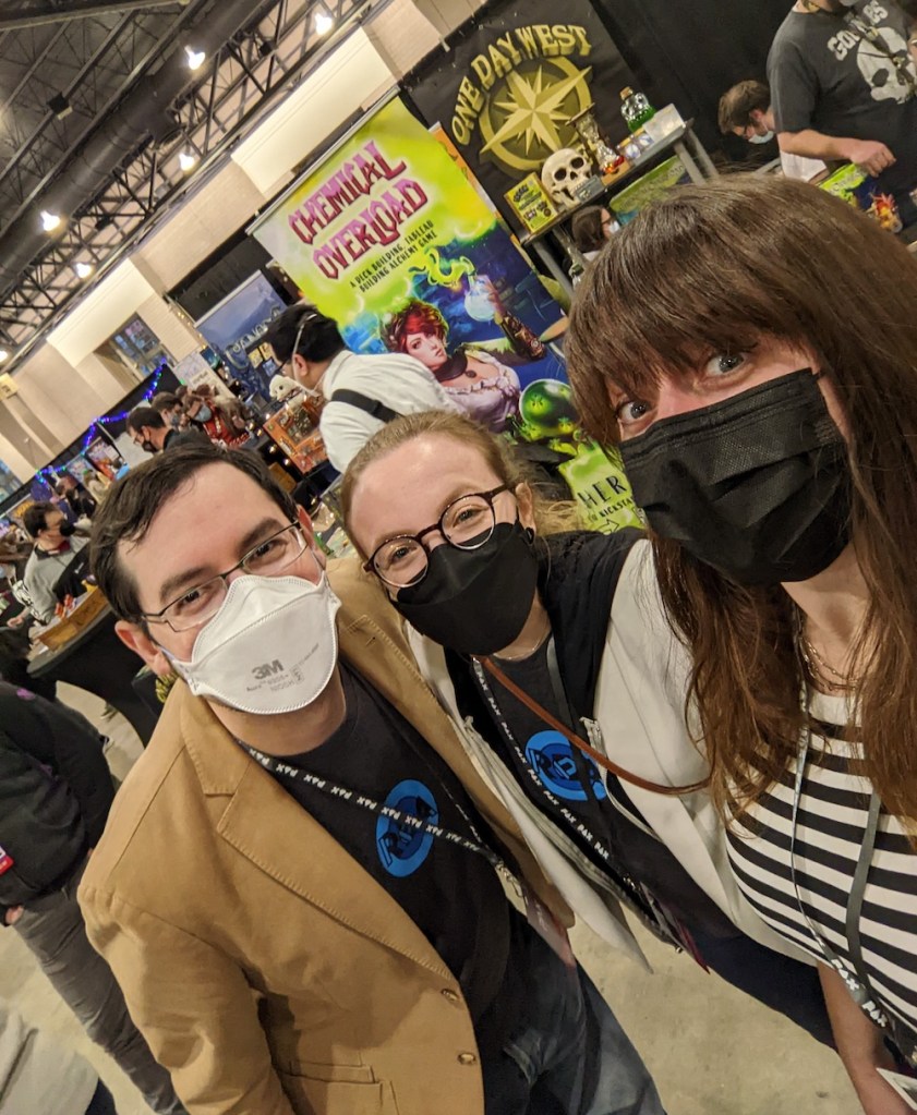 David, Lisa, & Theresa on the floor of PAX Unplugged 2022.