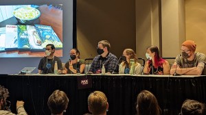 David, Michelle, Mark, Lisa, Rita, and Jack on stage at their PAX Unplugged 2022 tabletop gaming panel.