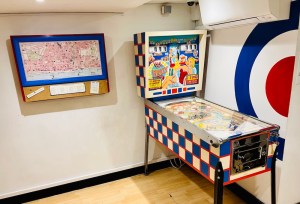 An old "Hi Dolly" pinball machine between a map of Brighton and half of The Who bullseye logo.