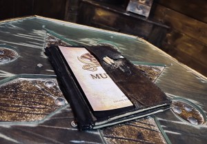 Closeup of a journal on a small table in a pirate ship.