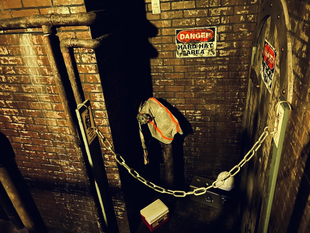 Some construction equipment, a safety vest, and helmet in a sewer.