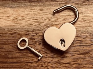 Closeup of an unlocked golden heart lock.